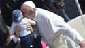 Le pape François embrasse un enfant place Saint-Pierre au Vatican le 8 mai 2013.