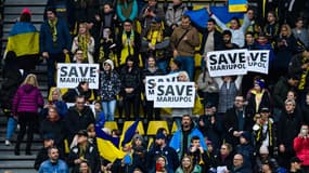 Des supporters de Dortmund avec des pancartes "Save Mariupol" lors du match de charité du Dynamo Kiev