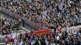 Les porteurs de cercueils, à côté des gardes suisses, accompagnent le cercueil du pape François lors de son transport de la chapelle de Santa Marta à la basilique Saint-Pierre au Vatican, le 23 avril 2025. 