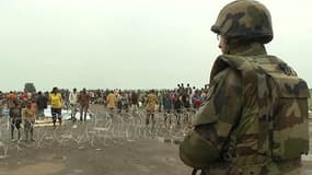 Un soldat fait face à des habitants de Bangui venus se réfugiés au plus près des troupes françaises, le 6 décembre.