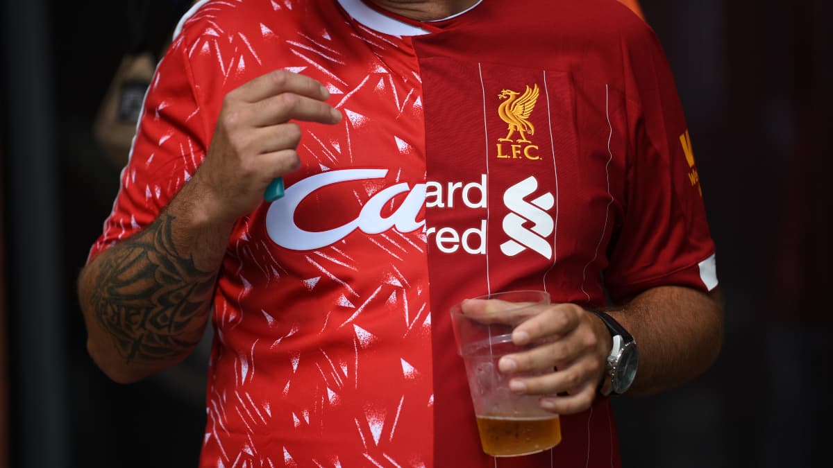 Un fan de Liverpool porte un maillot composé de la moitié de celui du titre de 1990 et de la moitié de celui du titre de 2020 Un fan de Liverpool porte un maillot composé de la moitié de celui du titre de 1990 et de la moitié de celui du titre de 2020