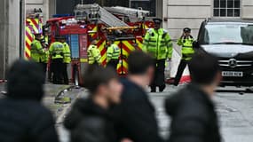 Des policiers et des pompiers se tiennent autour des tentes délimitant la scène d'un accident dans Water Street, en marge de la parade de la victoire de Liverpool en Premier League, en l'Angleterre, le 26 mai 2025.