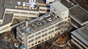 Sur le toit d'un immeuble à Kesennuma, dans la préfecture de Miyagi. Le Japon s'est réveillé samedi matin face à un spectacle de désolation après le gigantesque tremblement de terre et le tsunami qui ont touché le nord-est de l'archipel faisant plus d'un