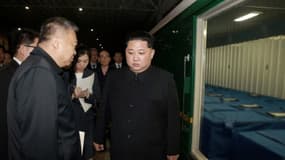 Photo fournie par l'agence nord-coréenne Kcna du leader nord-coréen Kim Jong-Un (d) et l'ambassadeur chinois en Corée du Nord, Li Jinjun (g) avant le départ d'un train rapatriant les corps de touristes chinois tués dans un accident d'aut...