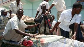 Des soldats et des secouristes transportent le corps d'un député. Des hommes en uniforme de l'armée ont attaqué mardi un hôtel de Mogadiscio, non loin du palais présidentiel, tuant au moins 31 personnes dont six députés. L'attaque a été revendiquée par le