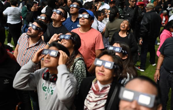 Les gens regardent l'éclipse solaire annulaire au planétarium de l'Institut national polytechnique (IPN), à Mexico, au Mexique, le 14 octobre 2023. 