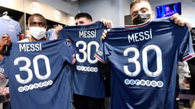 Des supporters du PSG posent avec le maillot de Lionel Messi floqué de son numéro 30