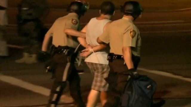 Interpellation d'un manifestant par la police, dans la nuit de lundi à mardi à Ferguson, dans le Missouri.