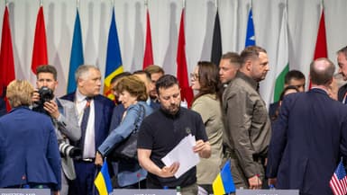 Le président ukrainien Volodymyr Zelensky examine des documents alors qu'il assiste à une séance plénière du Sommet sur la paix en Ukraine.