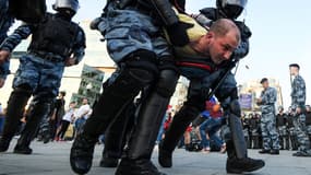 Des policiers arrêtant un manifestant en Russie