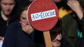 Un opposant au projet d'autoroute A69 entre Toulouse et Castres tient un panneau où il est inscrit "A69=Ecocide", le 21 octobre 2023 à Saïx, près de Castres