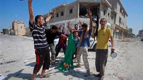 Insurgés libyens dans la ville de Zaouïah. L'armée libyenne et les rebelles continuaient de combattre samedi pour le contrôle de Zaouïah et Zlitane, deux villes côtières encadrant la capitale, Tripoli. /Photo prise le 20 août 2011/REUTERS/Bob Strong
