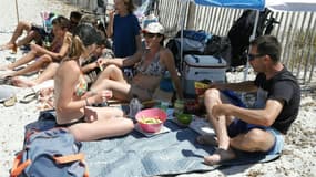 Des touristes font un pique-nique sur la plage corse de Mare e Sol à Pietrosella, le 12 août 2023 