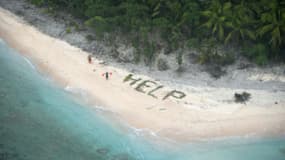Les trois hommes ont été aperçus grâce au mot HELP écrit sur le sable.