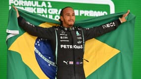 Le pilote britannique Lewis Hamilton (Mercedes) célèbre sur le podium, avec le drapeau brésilien, sa victoire dans le Grand Prix du Brésil de Formule 1, le 14 novembre sur le circuit d'Interlagos à Sao Paulo