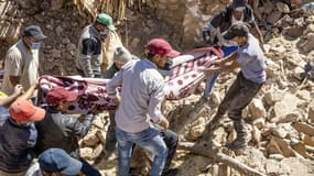Des bénévoles recouvrent un corps retrouvé dans les décombres de maisons détruites au Sud de Marrakech deux jours après le séisme, le 10 septembre 2023
