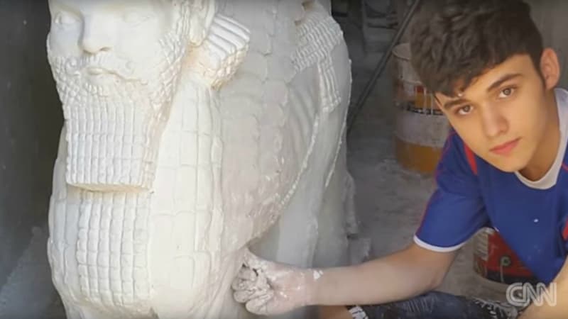Nenous Thabit à côté de sa réplique d'une statue à l'effigie d'un Lamassu, une divinité assyrienne.