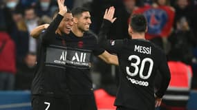 La joie de l'attaquant du Paris Saint-Germain, Kylian Mbappé, félicité par le Marocain Achraf Hakimi et l'Argentin Lionel Messi, après avoir ouvert le score face à Nantes, lors de la 14e journée de Ligue 1, le 20 novembre 2021 au Parc des Princes