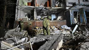 Un agent des forces de l'ordre ukrainiennes se tient parmi des décombres à Kharkiv, en Ukraine, le 20 décembre 2024