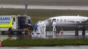 Du personnel médical prend en charge un malade du Covid-19 arrivé par avion médicalisé d'une région où les hopitaux sont débordés, à l'aéroport de Nantes-Atlantique, à Bouguenais, le 27 octobre 2020