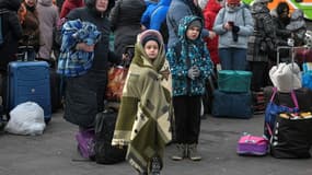 Des réfugiés attendent avec leurs bagages de monter à bord de cars à Przemysl, en Pologne, près de la frontière ukrainienne le 8 mars 2022.