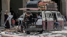 Des Palestiniens qui ont fui Rafah, dans le sud de la bande de Gaza, déchargent leurs affaires de l'arrière d'un camion à leur arrivée pour se réfugier à Khan Yunis le 12 mai 2024, au milieu du conflit en cours entre Israël et le groupe militant du Hamas.