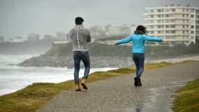 Des passants marchent sous la pluie et au milieu du vent le long de la plage Milady, lors du passage de la tempête Ciaran, à Biarritz, le 3 novembre 2023
