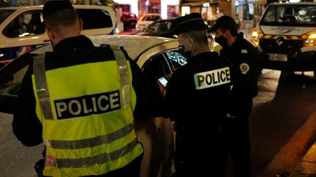 Des policiers français contrôlent les autorisations de sortie des automobilistes sur la route longeant la "Promenade des anglais" à Nice, sud de la France, pendant les heures de couvre-feu, le 30 janvier 2021