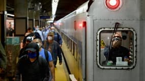 Des voyageurs sortent d'une rame de métro à la station de Grand Central, à Manhattan, le 8 juin 2020, première jour du début de déconfinement à New York