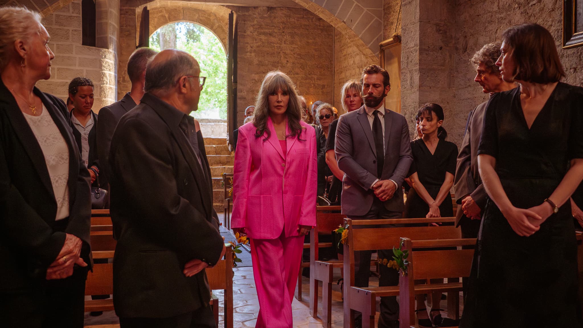 Béatrice Lasserre (Isabelle Adjani) arrives with a pink suit with her husband's funeral (Tibault from Montalembert) in Sun Noir (Netflix). Béatrice Lasserre (Isabelle Adjani) arrives with a pink suit with her husband's funeral (Tibault from Montalembert) in Sun Noir (Netflix).