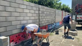 Un mur en construction devant une école à Arles
