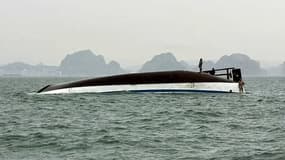 Un homme se tient sur un bateau de touristes qui a chaviré dans la baie d'Halong, province de Quang Ninh, le 19 juillet 2025.