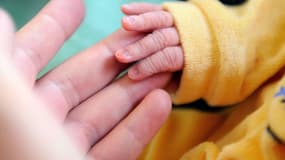 Un nouveau-né touche les doigts de sa mère (image d'illustration)