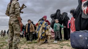 Image d'illustration - Enfants devant un soldat kurde, après avoir quitté l'État Islamique, le 27 février 2019  dans la province de Deir Ezzor, en Syrie.