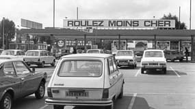 Photo prise en septembre 1975 de véhicules prenant de l'essence au rabais dans un supermarché en banlieue parisienne.