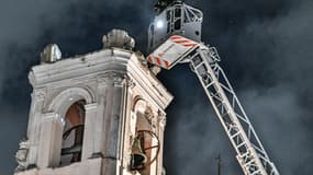 Des pompiers contrôlent la tour de l'église Sant'Anna à Bagnoli près de Naples, suite à un tremblement de terre de magnitude 4,4, le 13 mars 2025. 