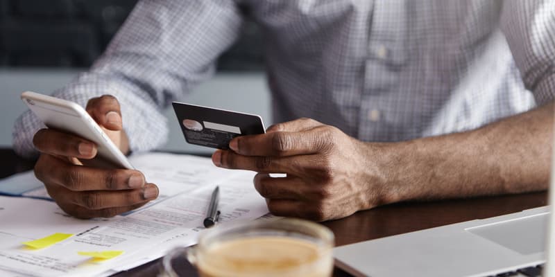 Un homme effectuant un virement bancaire depuis son téléphone (photo d'illustration).
