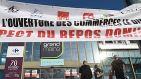 Une centaine de salariés du commerce et d'autres professions réunis en intersyndicale se sont rassemblés devant un hypermarché Carrefour d'Angers ouvert le dimanche matin.