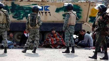 Manifestants installés près de chars de l'armée égyptienne, place Tahrir dans le centre du Caire. Les manifestants qui réclament depuis près de deux semaines la démission immédiate du président Hosni Moubarak sont encore loin de leur objectif. Le pouvoir