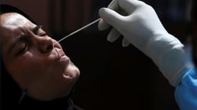 Une soignante se fait introduire un écouvillon dans le nez pour un test du Covid-19, à Srinagar (Inde), le 15 septembre 2021