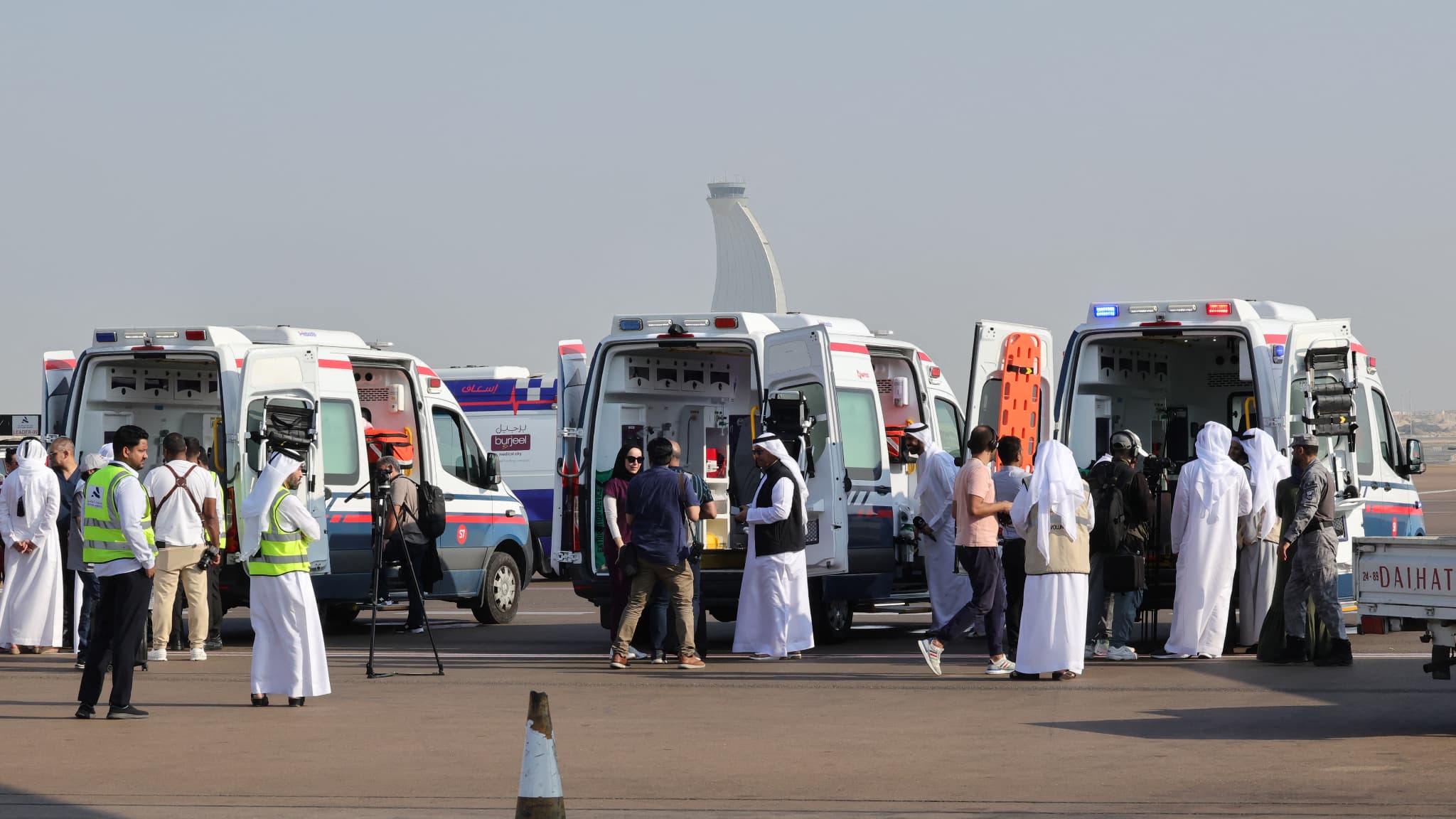 Des bénévoles et des ambulances attendent sur le tarmac à Abu Dhabi le 18 novembre 2023, à l'arrivée de l'avion transportant des Palestiniens évacués de Gaza dans le cadre d'une mission humanitaire organisée par les Émirats arabes unis.