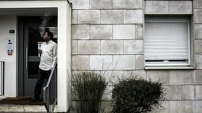 Un réfugié érythréen fume une cigarette à l'entrée de son appartement de la maison des réfugiés de Pouilly-en-Auxois, en Côte d'Or.