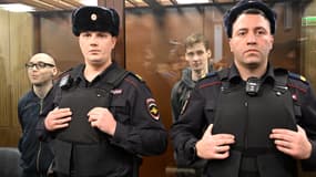 Les russes Artyom Kamardin et Yegor Shtovba se tiennent à l'intérieur de la cage de verre des accusés lors de l'annonce du verdict au tribunal de Moscou le 28 décembre 2023.