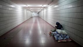 Un sans-abri dans un couloir du métro.