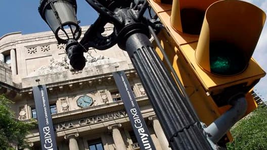 Devant le siège de la banque Catalunya Caixa, à Barcelone. L'Espagne fera "rapidement" une demande officielle à ses partenaires de la zone euro pour une aide pouvant atteindre jusqu'à 100 milliards d'euros, ont indiqué samedi les 17 ministres des Finances