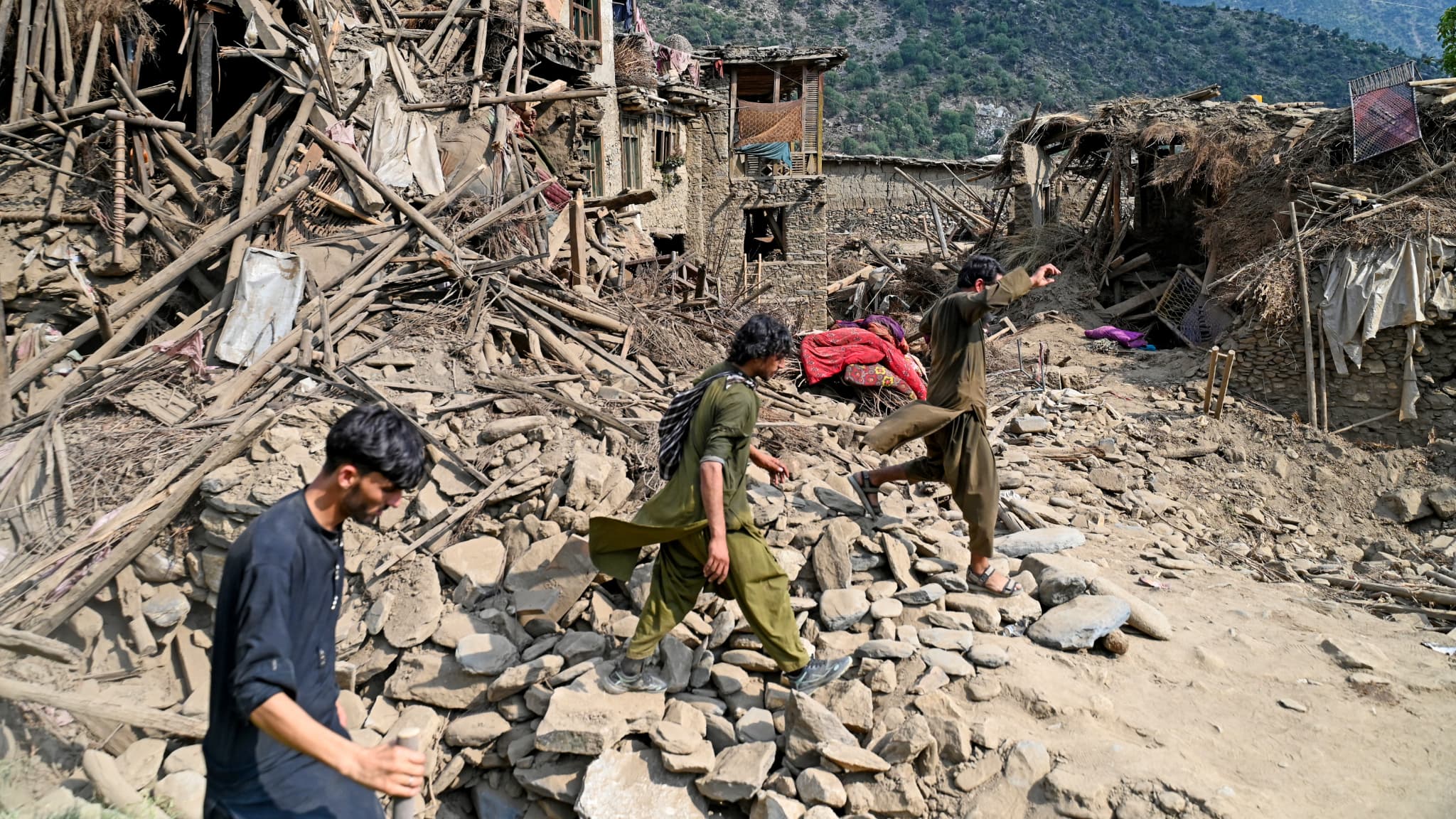 The Afghan pass through damaged houses after the earthquakes that arrived in the village of Mazar Dara, in the district of Nurgal, Kunar province, in eastern Afghanistan on September 1, 2025. The Afghan pass through damaged houses after the earthquakes that arrived in the village of Mazar Dara, in the district of Nurgal, Kunar province, in eastern Afghanistan on September 1, 2025.