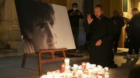 Un prêtre auprès de la photo d'Yvan Colonna, disposée sur le parvis de la cathédrale d'Ajaccio. 