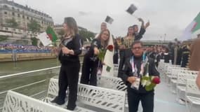 Des membres de la délégation olympique algérienne tiennent des roses rouges qu'ils vont lancer dans la Seine en hommage à leurs compatriotes tués par la police français lors de la cérémonie d'ouveture des JO à Paris, le 26 juillet 2024.