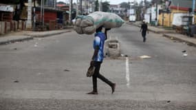 Une personne porte une charge sur la tête en marchant, à Lagos, au Nigeria, le 12 juillet 2025.