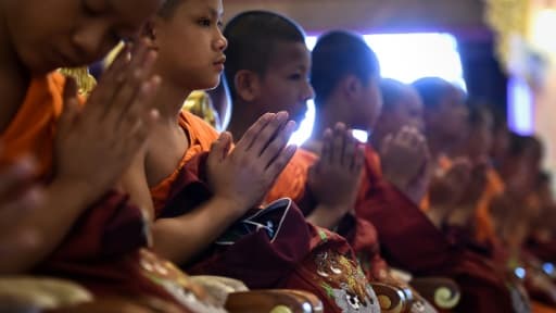 Les enfants thaïlandais rescapés d'une grotte inondée assistent à une cérémonie marquant la fin de leur retraite dans un monastère bouddhiste, le 4 août 2018 au temple Wat Phra That Doi Tung de Mae Sai, dans la province de Chiang Rai